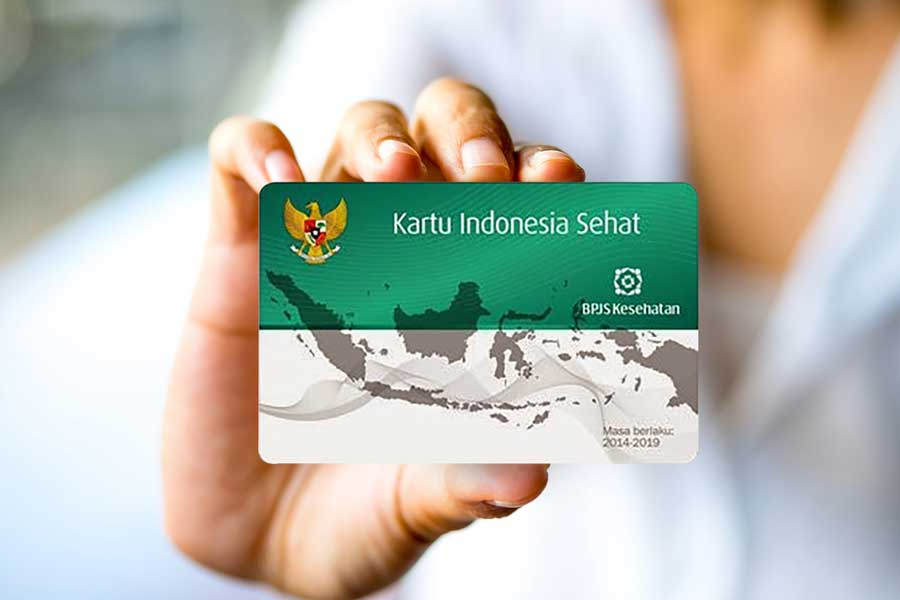 A person holds up a "Kartu Indonesia Sehat" (Healthy Indonesia Card) used for BPJS, Indonesia's national health insurance.